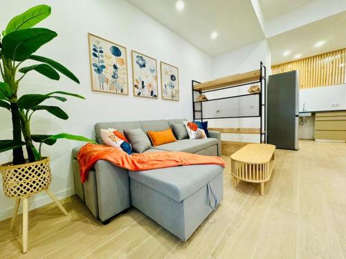 a living room with a couch with an orange blanket at LOFT 1 - Space & Conform Close To Center in Valencia