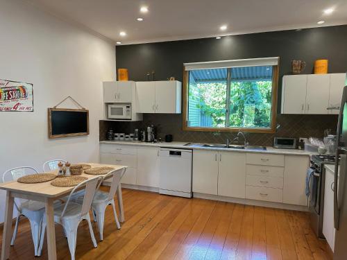 a kitchen with white cabinets and a table with chairs at Jack's House 2 B&B in Mill Street in Clare