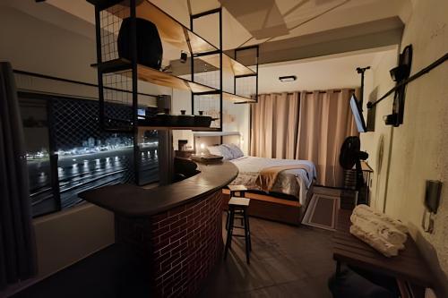 um quarto de hotel com uma cama e um bar em Apartamento "A Cabana da Ilha Porchat" em São Vicente