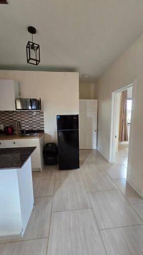 a kitchen with a black refrigerator in a room at Azure in Georgetown