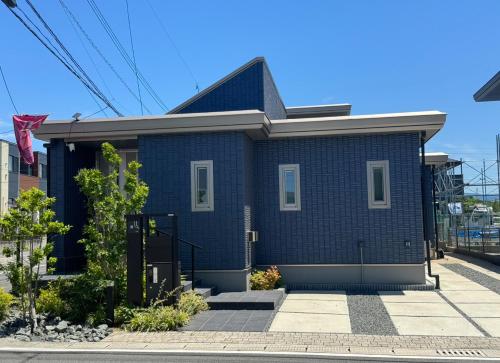una casa de ladrillo azul con una bandera. en Akikawa Koshi 8, en Yuge
