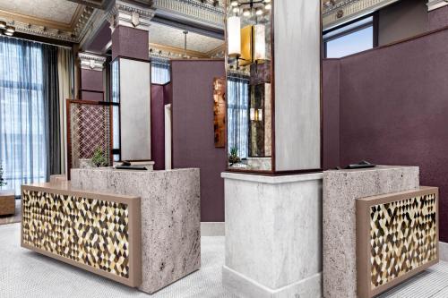 a lobby with three concrete pillars with gold accents at Courtyard by Marriott Cape Girardeau Downtown in Cape Girardeau