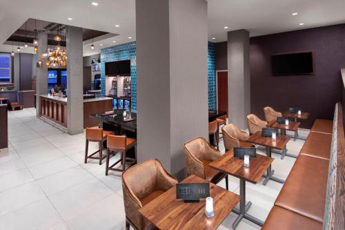 a restaurant with wooden tables and chairs and a bar at Courtyard by Marriott Cape Girardeau Downtown in Cape Girardeau