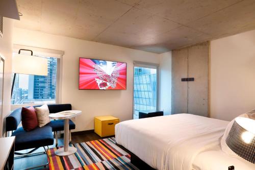 a hotel room with a bed and a chair and a window at Aloft Chicago Mag Mile in Chicago