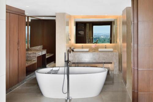 a bathroom with a bath tub and a sink at Courtyard by Marriott Bengaluru Hebbal in Bengaluru