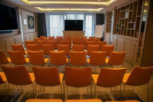 a conference room with orange chairs and a podium at Courtyard by Marriott Belgrade City Center in Belgrade