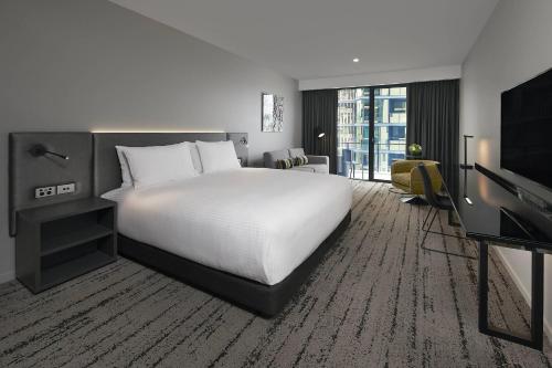 a hotel room with a bed and a television at Courtyard by Marriott Brisbane South Bank in Brisbane