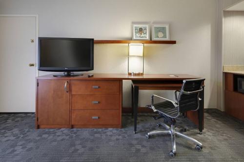 an office with a desk with a television and a chair at Courtyard Atlanta Marietta/I-75 North in Marietta