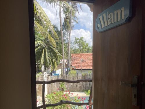 a window view of a yard with a palm tree at Kitekuda Kite Resort in Vannativillu