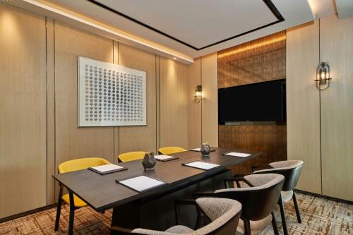 a conference room with a table and chairs and a television at Courtyard by Marriott Changchun in Changchun