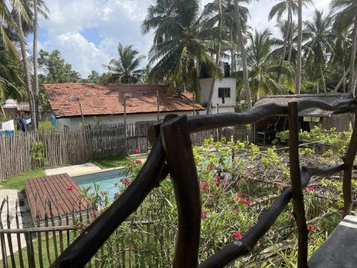 a fence in front of a house with a pool at Kitekuda Kite Resort in Vannativillu