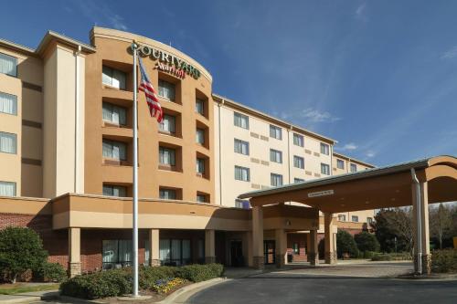 a hotel with an american flag in front of it at Courtyard by Marriott Atlanta Buford Mall of Georgia in Buford