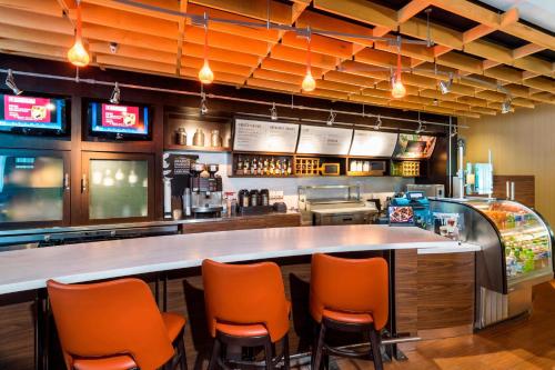 a bar with orange chairs in a restaurant at Courtyard by Marriott Atlanta Buford Mall of Georgia in Buford