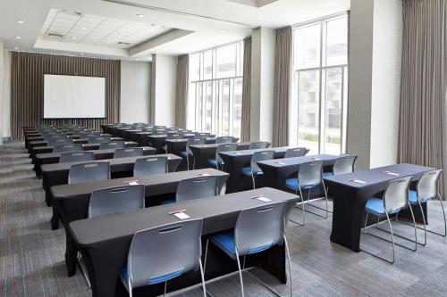 a conference room with tables and chairs and a whiteboard at Aloft Austin at The Domain in Austin