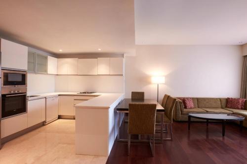 a kitchen and living room with a table and a couch at Courtyard by Marriott Mumbai International Airport in Mumbai