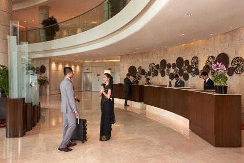 a man and a woman standing in a lobby at Courtyard by Marriott Mumbai International Airport in Mumbai