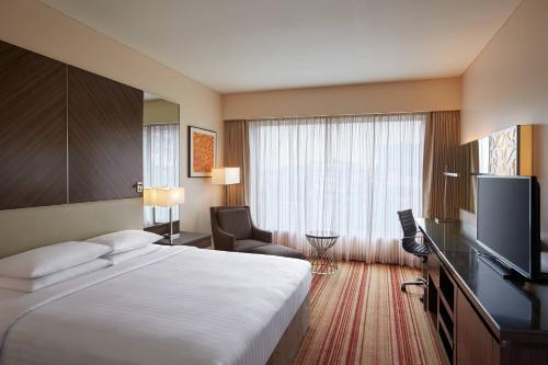 a hotel room with a bed and a flat screen tv at Courtyard by Marriott Mumbai International Airport in Mumbai