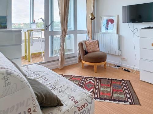 un salon avec un canapé et une chaise dans l'établissement Charmant Studio à Courseulles-sur-Mer avec Wifi et Parking - FR-1-746-27, à Courseulles-sur-Mer