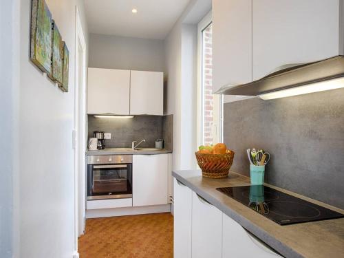 une cuisine avec des armoires blanches et un comptoir dans l'établissement Studio cosy avec vue sur mer à Cabourg, idéal pour deux - FR-1-788-48, à Cabourg