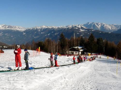 eine Gruppe von Menschen, die im Schnee auf einer Skipiste stehen in der Unterkunft Casa Andreoli in Teglio