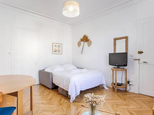 une chambre blanche avec un lit et une télévision dans l'établissement Studio cosy avec vue sur mer à Cabourg, idéal pour deux - FR-1-788-48, à Cabourg