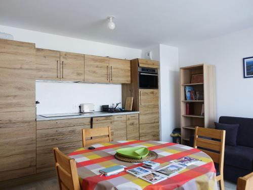 une cuisine et une table avec une plaque de cuisson verte dans l'établissement Appartement 2 à 4 personnes, proche du Golfe du Morbihan - FR-1-639-131, à Sarzeau