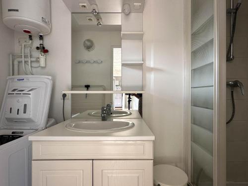 une salle de bain blanche avec un lavabo et un miroir dans l'établissement Villa 4 Pièces, 3 Chambres, Animaux Acceptés, Parking, WiFi, Proche Mer - FR-1-705-92, aux Mathes