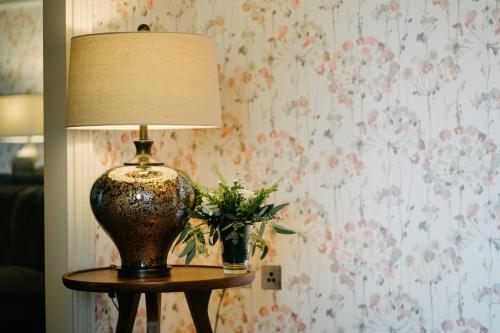 a lamp on a table with a vase of flowers at Mount Juliet Estate, Autograph Collection in Thomastown