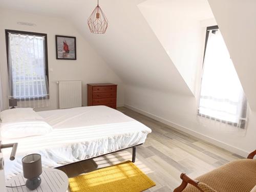 une chambre blanche avec un lit et une chaise dans l'établissement Maison familiale pour 6 personnes à Sarzeau - Secteur Brillac - FR-1-639-130, à Sarzeau