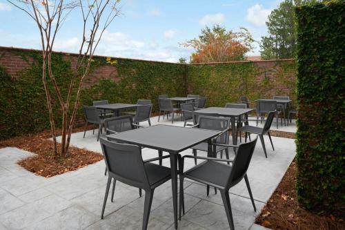 a patio with tables and chairs and a hedge at Courtyard by Marriott Charleston Summerville in Summerville