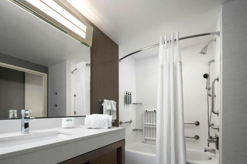 a bathroom with a tub and a sink and a shower at Courtyard by Marriott Denver North/Westminster in Eastlake