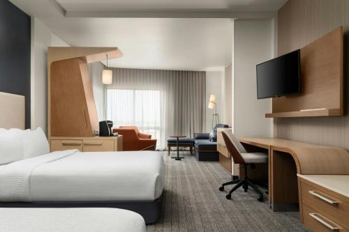 a hotel room with two beds and a desk at Courtyard by Marriott Denver North/Westminster in Eastlake