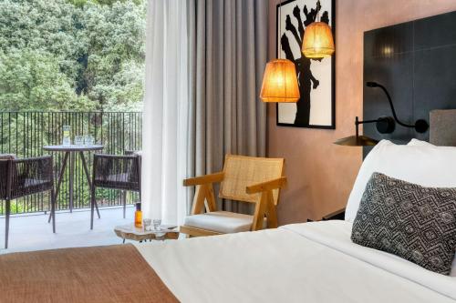 a hotel room with a bed and a balcony at Domes of Corfu, Autograph Collection in Glyfada