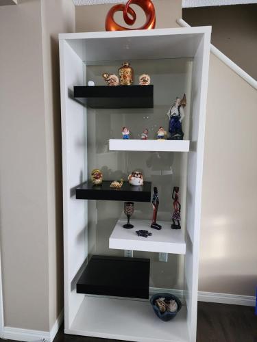 a white book shelf with figurines on it at Cozy Luxury House in Edmonton