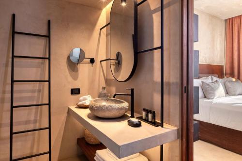 a bathroom with a sink and a bed at Domes of Corfu, Autograph Collection in Glyfada