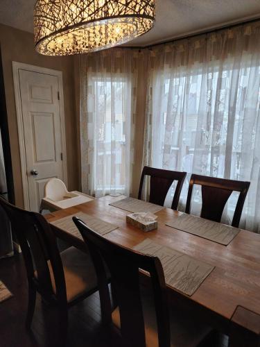 a dining room table with chairs and a chandelier at Cozy Luxury House in Edmonton