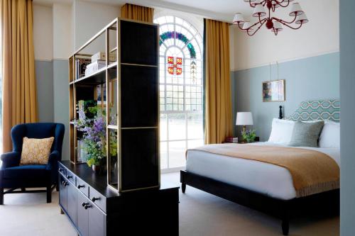 a bedroom with a bed and a dresser and a window at University Arms, Autograph Collection in Cambridge