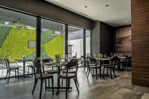 a restaurant with tables and chairs and large windows at Courtyard by Marriott Ciudad Juarez in Ciudad Juárez