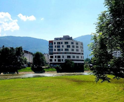a building in a field next to a river at ILiDZA SKY in Sarajevo