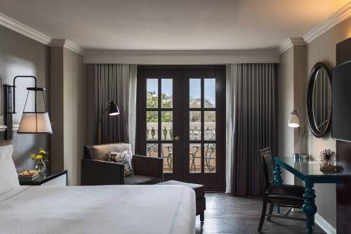 a hotel room with a bed and a desk and a window at The Lindy Renaissance Charleston Hotel in Charleston