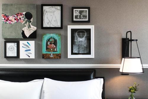 a room with a bed and framed pictures on a wall at The Lindy Renaissance Charleston Hotel in Charleston