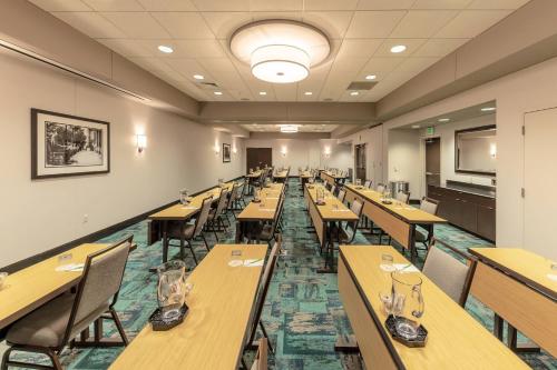 a dining room with wooden tables and chairs at Courtyard by Marriott Greenville Downtown in Greenville
