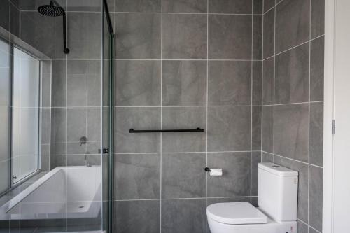 a bathroom with a shower and a toilet and a tub at Mayfield Modern Haven in Mayfield