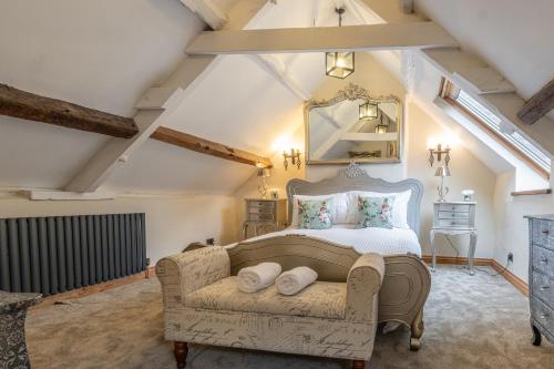 a bedroom with a bed and a couch at Eilmers Cottage - Beautiful 4BD in Malmesbury! in Malmesbury