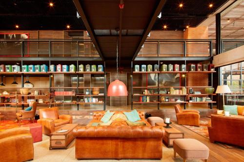 a living room with a couch and chairs and shelves at The Artisan D.C. Hotel, Autograph Collection in Bogotá