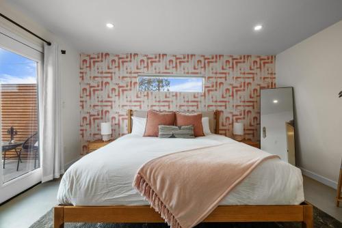 a bedroom with a large bed and a large window at Peaceful Desert Escape with Pool, Fire Pit and Stargazing Views in Yucca Valley