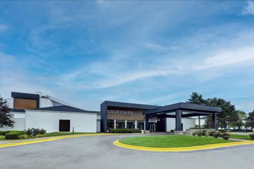 a large white building with a black roof at Courtyard Chicago Glenview/Northbrook in Glenview