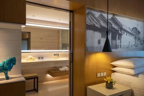 a bedroom with a bed and a sink and a mirror at Renaissance Beijing Wangfujing Hotel in Beijing