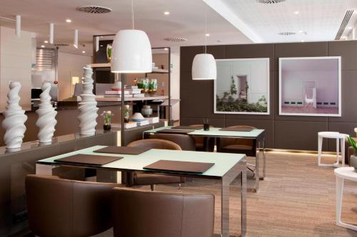 a dining room with two tables and chairs at AC Hotel San Cugat by Marriott in Sant Cugat del Vallès
