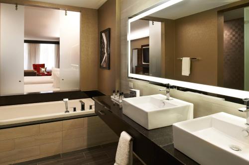 a bathroom with two sinks and a large mirror at Metropolitan at The 9, Autograph Collection in Cleveland